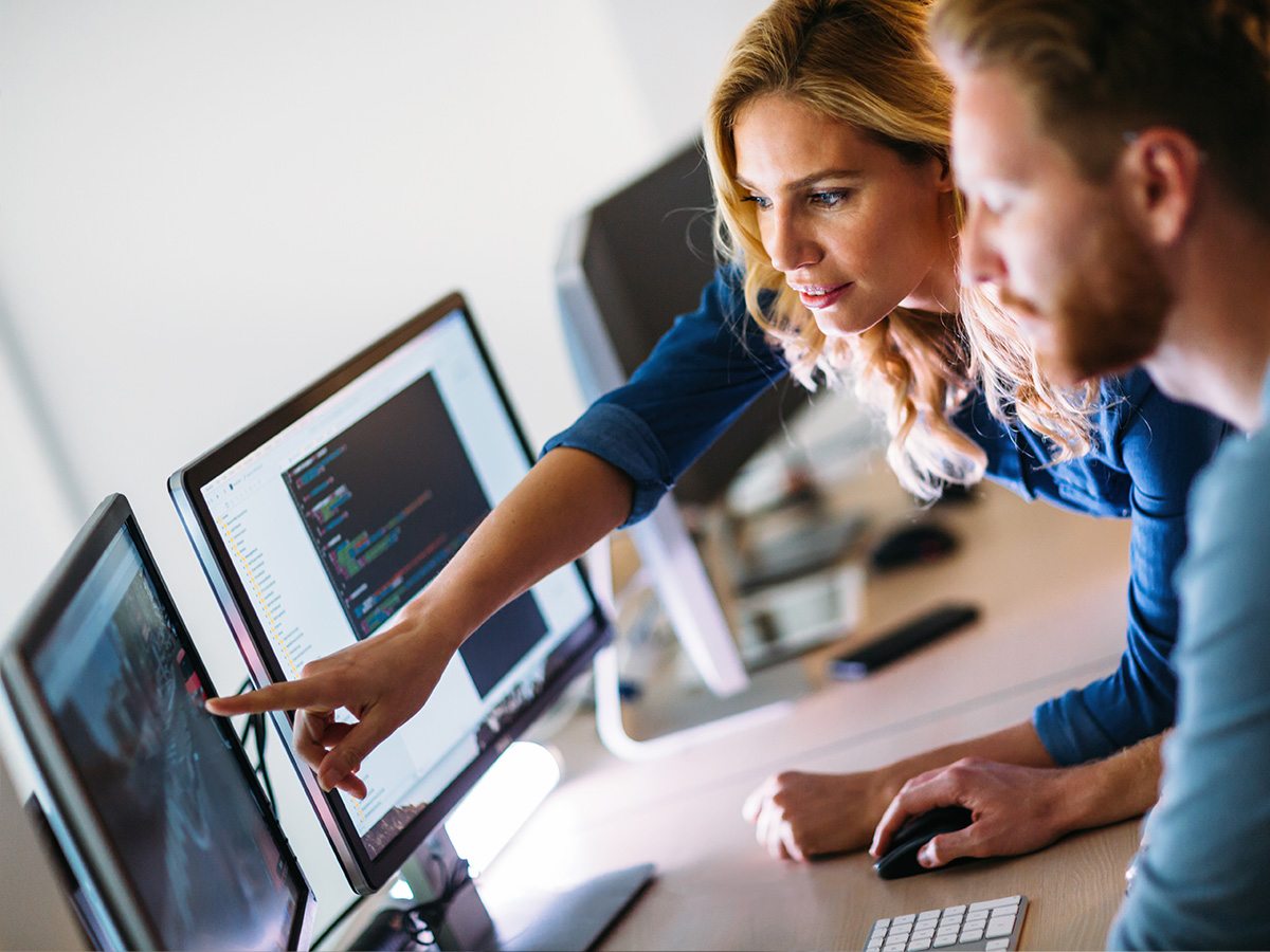 Senior analytics engineer teaching data intelligence to programmer on computer screen