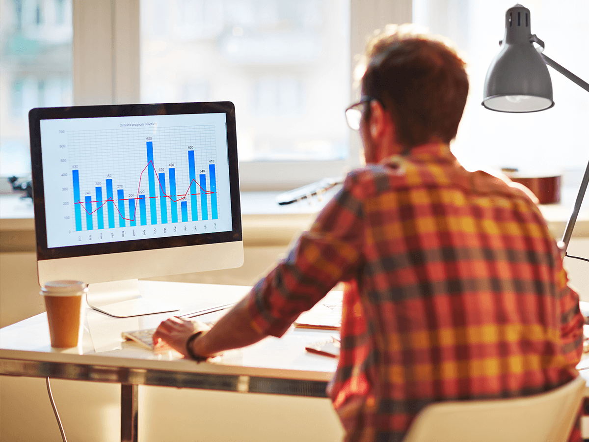 Software engineer in front of digital performance charts screen